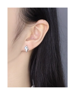 Detailed view of an irregular geometric silver earring with a round blue opal on ear