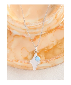 Macro view of S925 sterling silver star pendant with a blue opal stone inlay