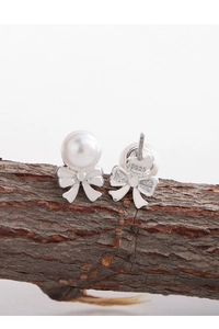 Macro detail of S925 sterling silver stamp on elegant bow pearl stud earrings