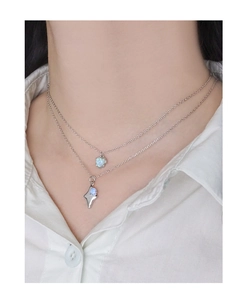 Detail of S925 silver layered necklace featuring blue opal starburst pendants on a model