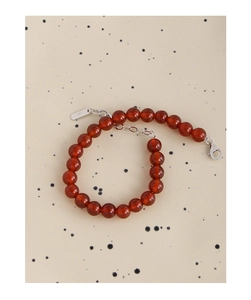 Detailed macro view of S925 sterling silver tag and clasp on red agate beaded bracelet