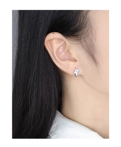 Close-up of S925 silver starburst stud earring with blue opal on a model ear