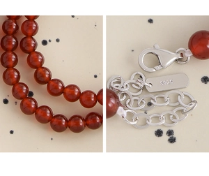 Detailed view of red agate beads and S925 sterling silver hallmark on the necklace clasp
