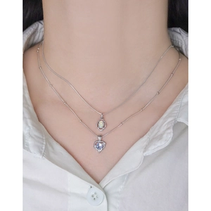 Double-layered S925 silver necklace with opal and purple heart pendant on a model