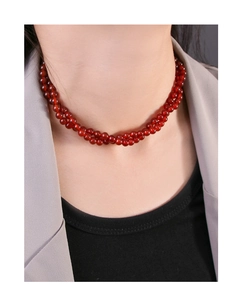 Close-up of double-layer red agate beaded necklace on neck over stylish grey blazer