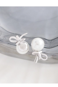 Macro shot of S925 sterling silver bow earrings showing hallmark and pearl texture