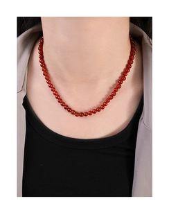 Close-up of red agate beaded necklace on a model showing the elegant gemstone texture