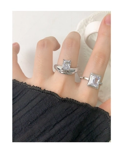 Primo piano di anelli in argento S925 con zirconi quadrati indossati al dito in stile moderno