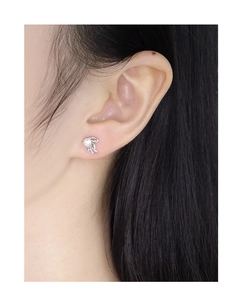 Detailed view of hollow wing silver earrings with round pearls on a female model
