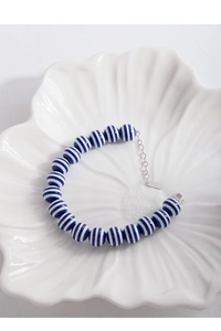 Close-up of S925 silver tag and navy blue striped beads on an adjustable bracelet