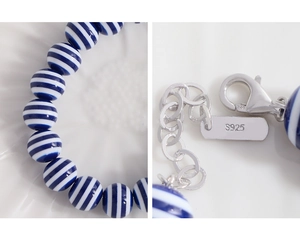 Detailed close-up of S925 sterling silver lobster clasp and blue striped beaded bracelet