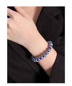 Detail of S925 silver bracelet featuring blue and white striped round ceramic beads