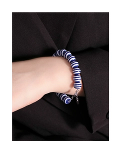 Detail of S925 silver beaded bracelet with navy blue stripes on a woman's wrist