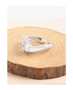 Dettaglio macro di anello in argento S925 con grande zircone rettangolare su legno