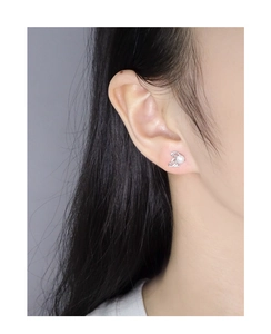 Close-up of elegant S925 silver hollow wing earrings with round white pearls on model