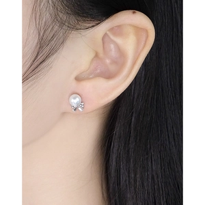Elegant S925 sterling silver bow pearl stud earrings shown on model ear for women