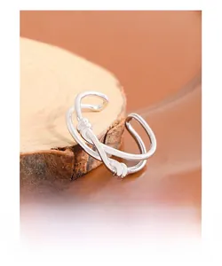 Detail view of S925 sterling silver double-layer knot ring on rustic wooden base