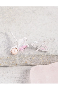 Macro shot of S925 silver stud earring with pink pearl, zircon, and bird-inspired design