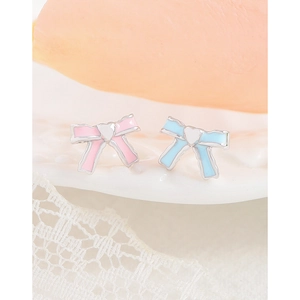 Pink and blue enamel bow stud earrings in 925 silver on a delicate lace ceramic plate