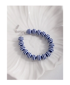 Close-up of S925 silver clasp on navy blue and white striped beaded ceramic bracelet