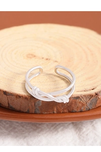 Close-up of S925 sterling silver double-layer knotted ring on a wooden display base
