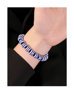 Close-up of S925 silver bracelet with navy blue and white striped round beads on wrist
