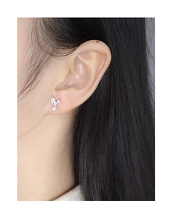 Macro shot of a minimalist S925 silver earring with zircon bunny ears and white pearl