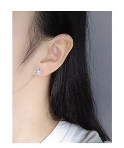 Close-up of S925 sterling silver flower stud earring worn on model for delicate detail
