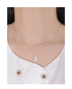 Detailaufnahme einer S925 Silber Opal Bärenkette mit Herzanhänger am Hals einer Frau