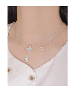 Nahaufnahme der S925 Silber-Halskette mit Opal-Bär und Herzanhänger an einem Model