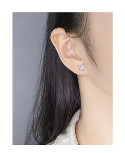 Detailed close-up of S925 silver leaf earring with pearl and zircon inlay on ear