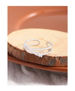Detailed view of S925 sterling silver double-layered knotted ring on wooden stand