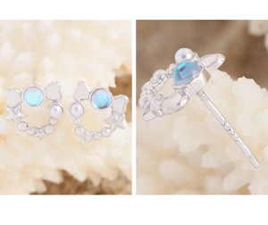 Detail of S925 sterling silver star earrings with iridescent blue gemstone and pearls