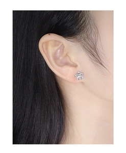 Close-up of S925 silver flower stud earring with zircon on a model ear