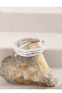 Close-up of S925 sterling silver ring with organic wavy texture on natural stone