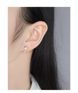 Close-up of S925 silver heart moonstone earrings with shell pendant on female model