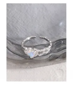 Dettaglio dell'anello a cuore in pietra di luna con fascia in argento testurizzato