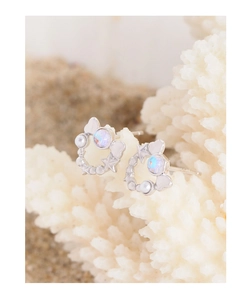 Macro detail of S925 silver star earring with opal and pearls on coral background
