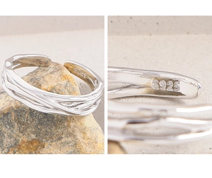 Macro detail of S925 sterling silver hallmark on minimalist multi-layer interlaced ring
