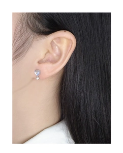 Detail of S925 silver heart earring with glowing moonstone on model's ear