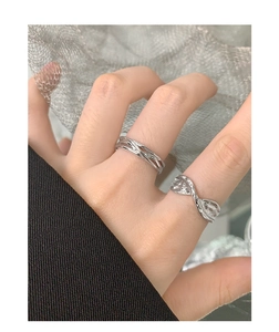 Detail of s925 silver rings set with twisted lines and wave textures on hand