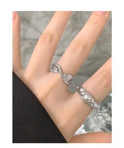 Close-up of S925 silver rings with lava texture and central pearl on a model hand