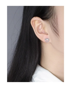 Detail of S925 silver moon and star stud earring with glowing moonstone on ear