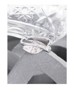 Macro shot of silver S925 ring with irregular lava texture on geometric stone stand