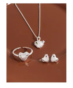 Macro detail of S925 silver heart jewelry set with micro-pave green zircon and lava texture