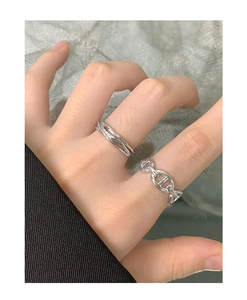 Detail view of layered twist design and anchor chain rings worn on a hand