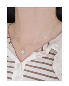 Close-up of S925 sterling silver heart pendant necklace on model neck with fine chain