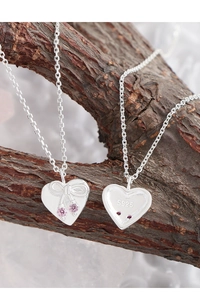 Detail of S925 sterling silver heart necklace with bow and pink zircon inlay