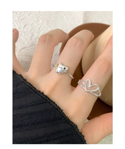 Close-up of S925 silver ring set with zircon animal and hollow heart design on a finger