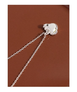 Close-up of S925 sterling silver heart pendant with micro-set zircon on smooth background
